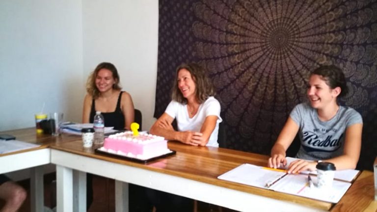 Three students celebrate a birth in a Costa Rican Spanish class